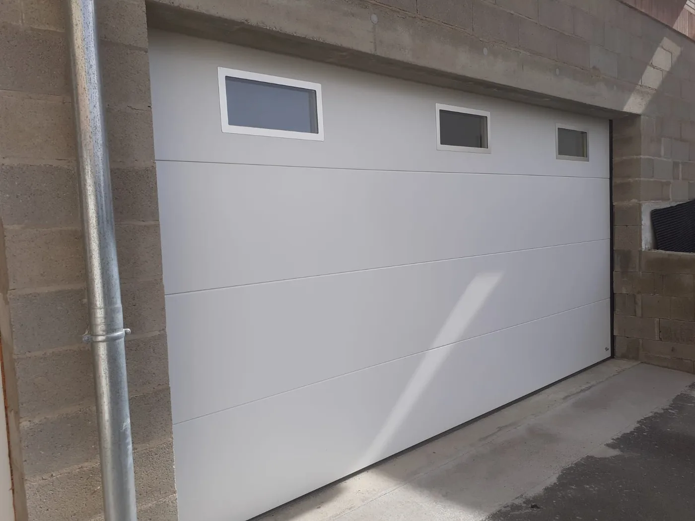 Exemple de porte de garage sectionnelle blanche avec hublots